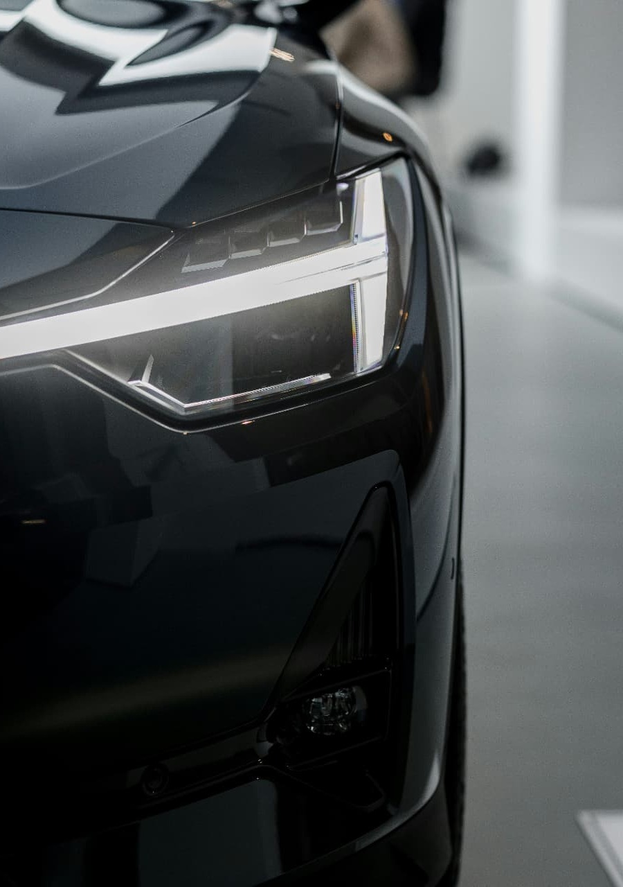 Dark electric vehicle parked at a modern Australian home at dusk